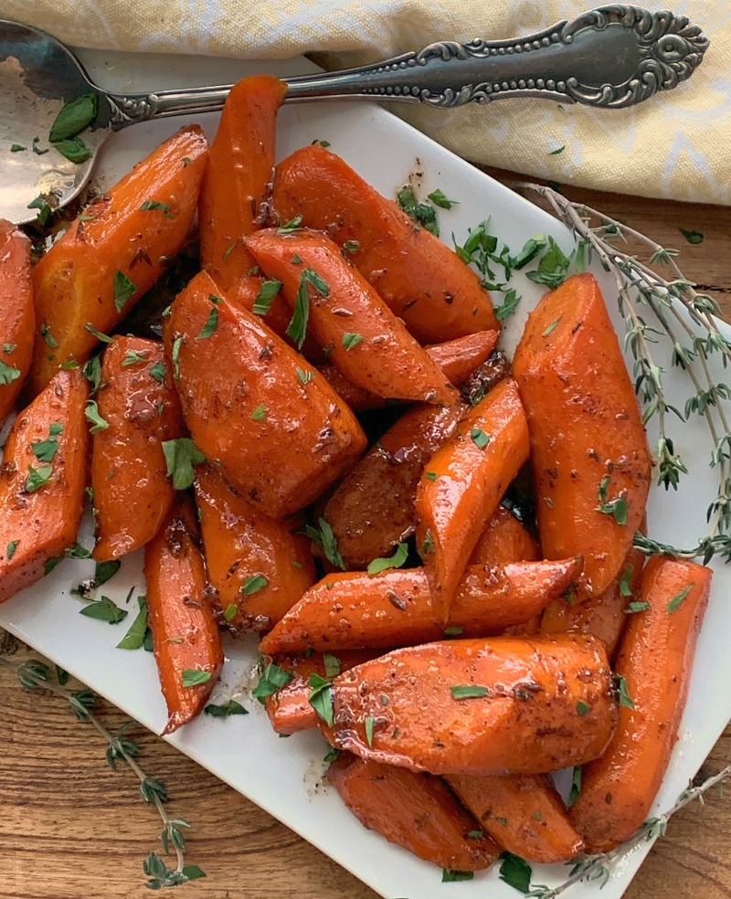 white plate with slow cooker glazed carrots garnished with parsley