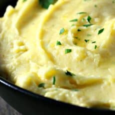creamy potatoes in black bowl topped with fresh chives