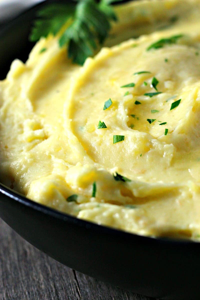 creamy potatoes in black bowl topped with fresh chives