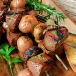 closeup of steak kabob garnished with rosemary sprig