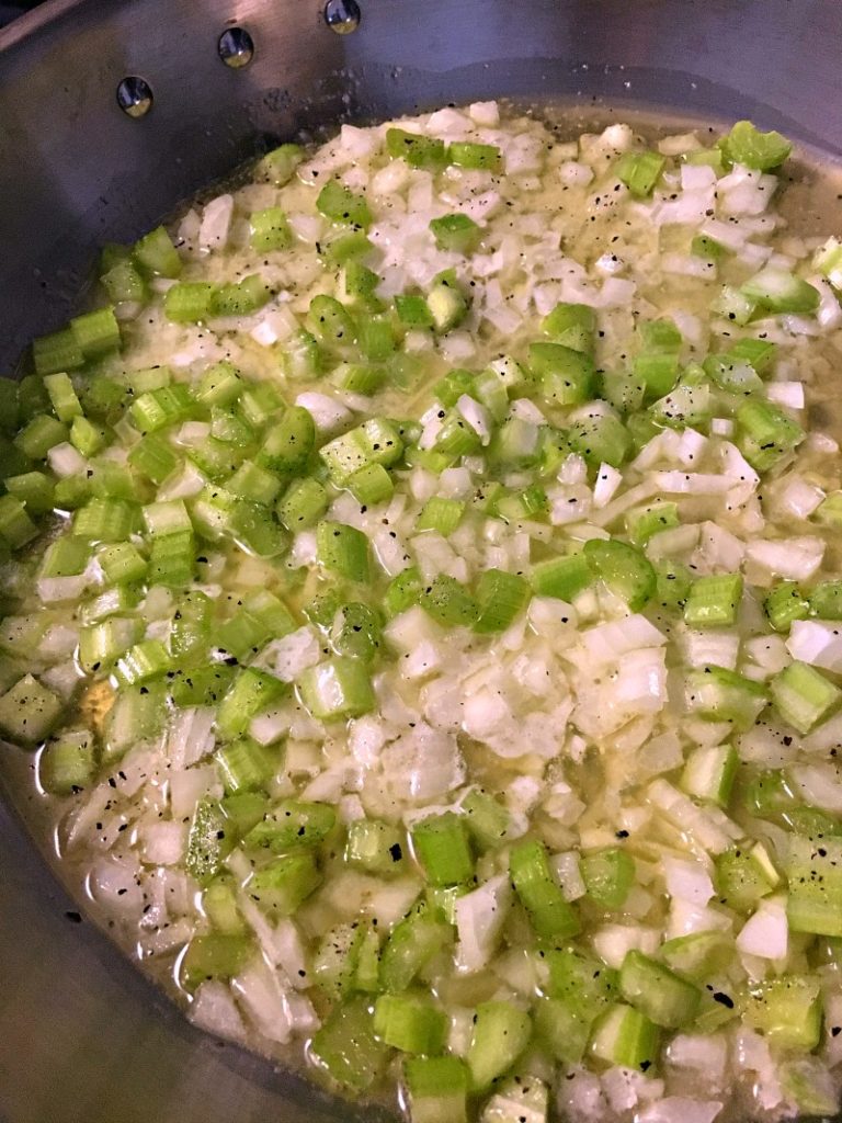 skillet with onions and celery sauteeing in butter for sausage herb stuffing