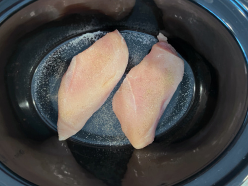 overhead view with chicken in slow cooker for one of the best super bowl recipes