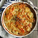 overhead view yukon gold sweet potato au gratin garnished with fresh thyme sprig