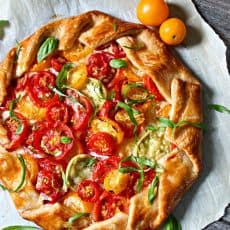 overhead view of whole tomato galette garnished with sliced basil