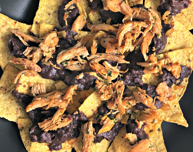 Ultimate Chicken Nachos ~ the ideal crowd-pleaser. Tortilla chips, chicken, refried black beans, lots of cheese, jalapeno, avocado, salsa & sour cream. Ole!