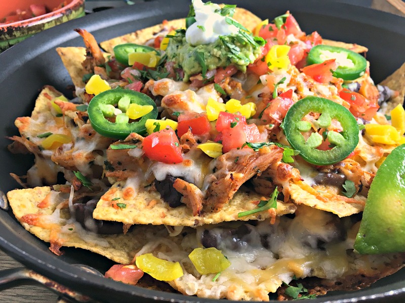 Ultimate Chicken Nachos ~ the ideal crowd-pleaser. Tortilla chips, chicken, refried black beans, lots of cheese, jalapeno, avocado, salsa & sour cream. Ole!